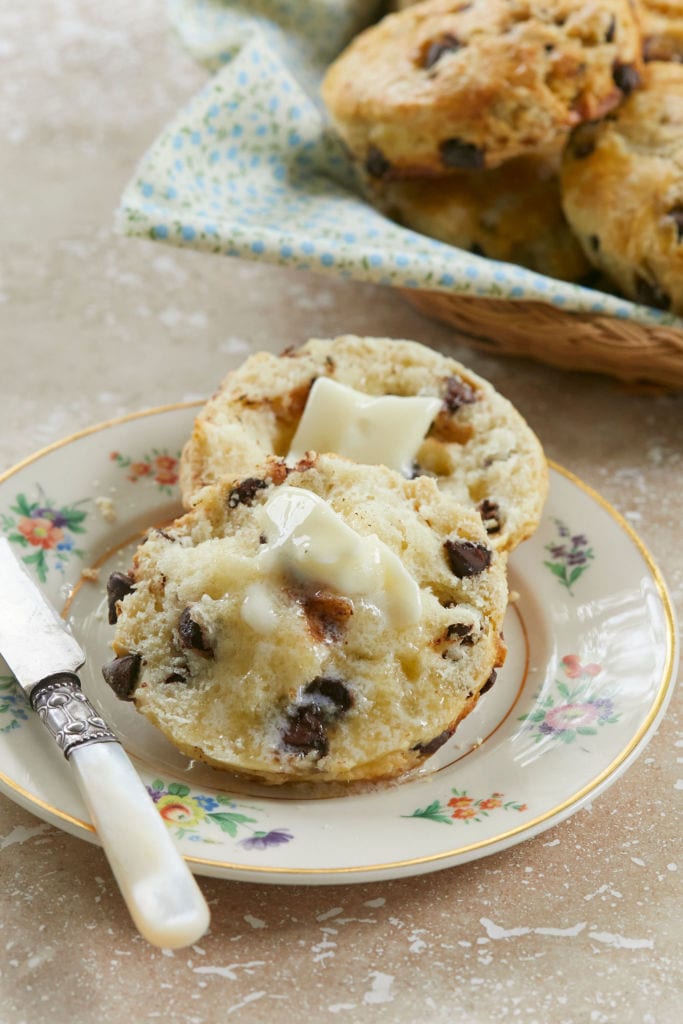 A cut open Chocolate Chip Scone from Bigger Bolder Baking's Easy Chocolate Chip Scones recipe, to show texture topped with butter.