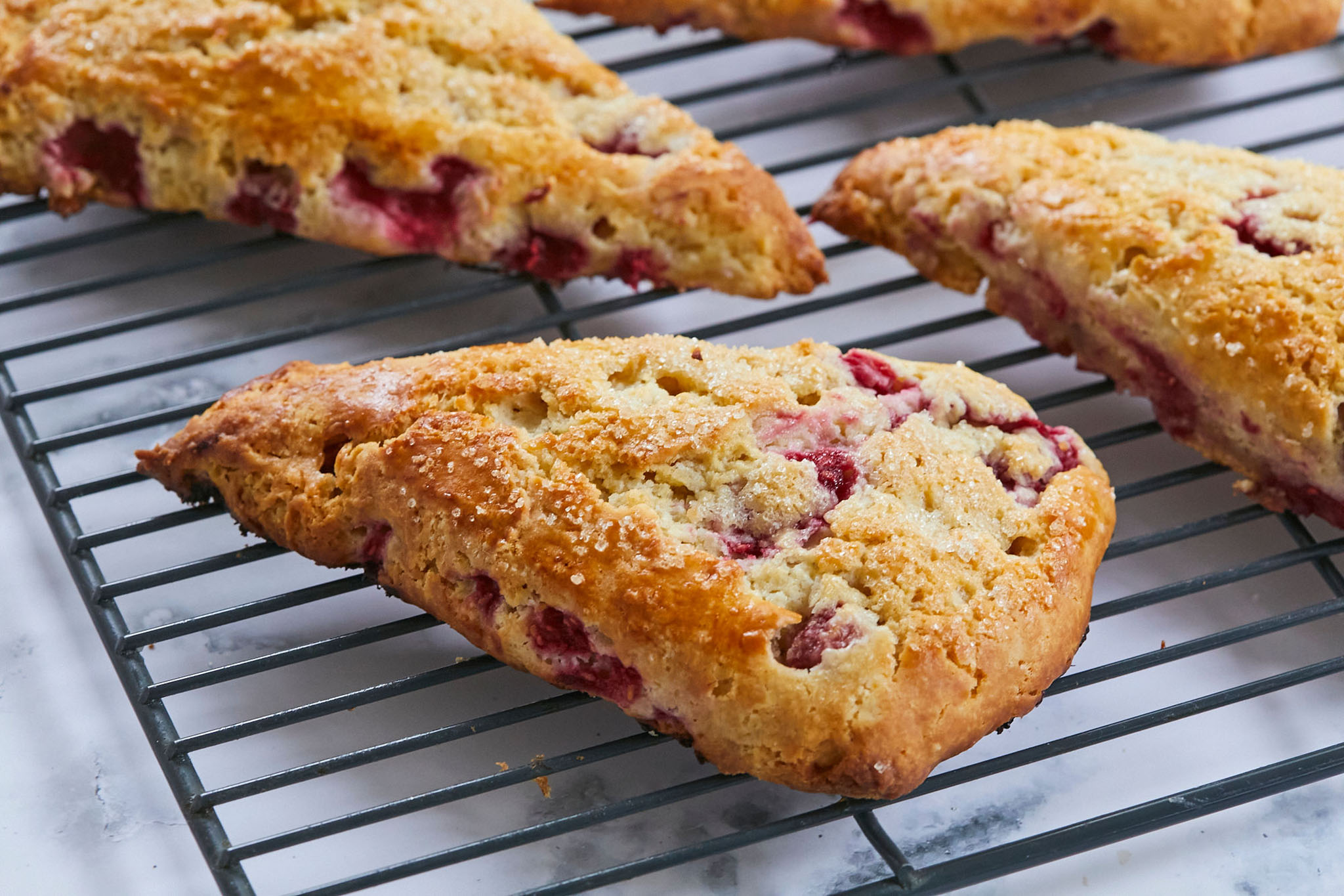Simple Raspberry Scones arranged on a cooling rack after baking.