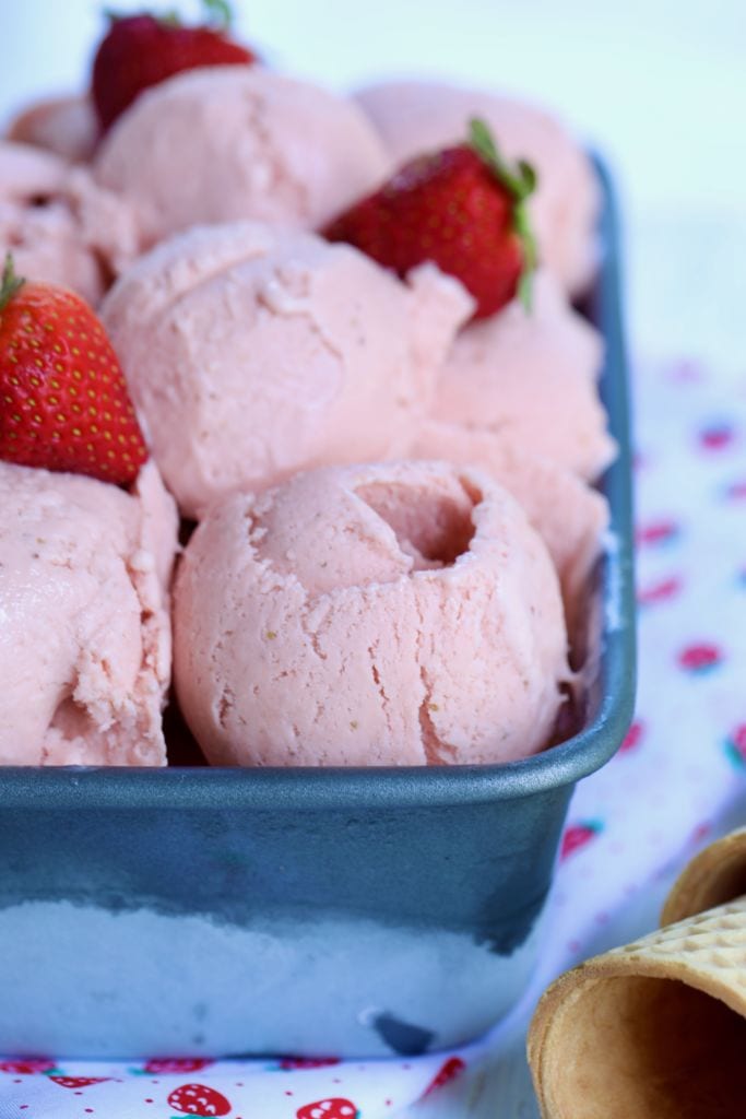 A tray of homemade strawberry gelato, surrounded by cones.