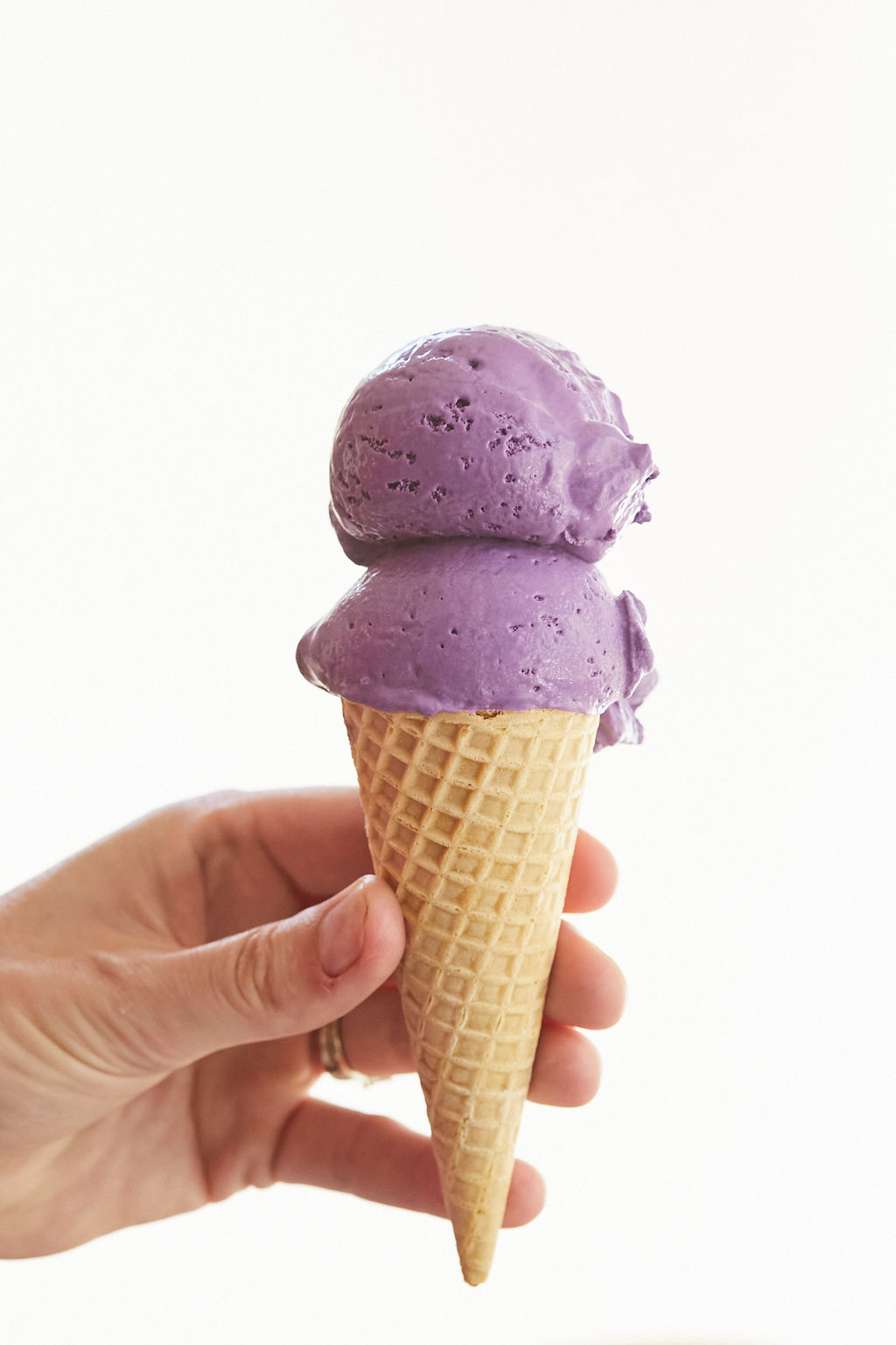 Two scoops of Ube Ice Cream sitting on top of a cone.