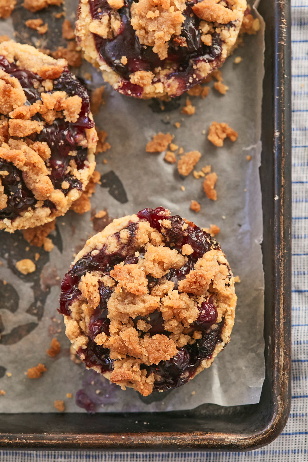 Overhead photo of Blueberry Crumb Pies highlighting the crumble topping on the juicy blueberry filling.