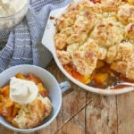 A serving of Best Peach Cobbler recipe topped with whipped cream.