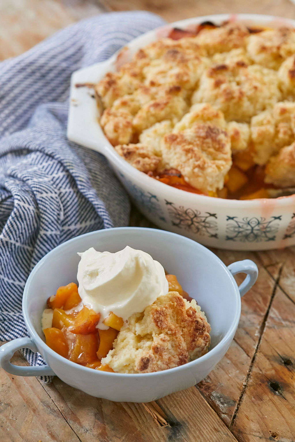 A serving of my Best Peach Cobbler recipe, topped with whipped cream, and ready to eat.