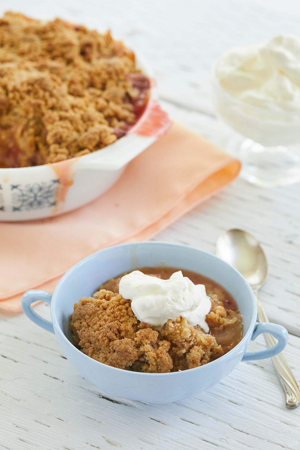 A portion of Rhubarb Crisp with a dollop of whipped cream on top.