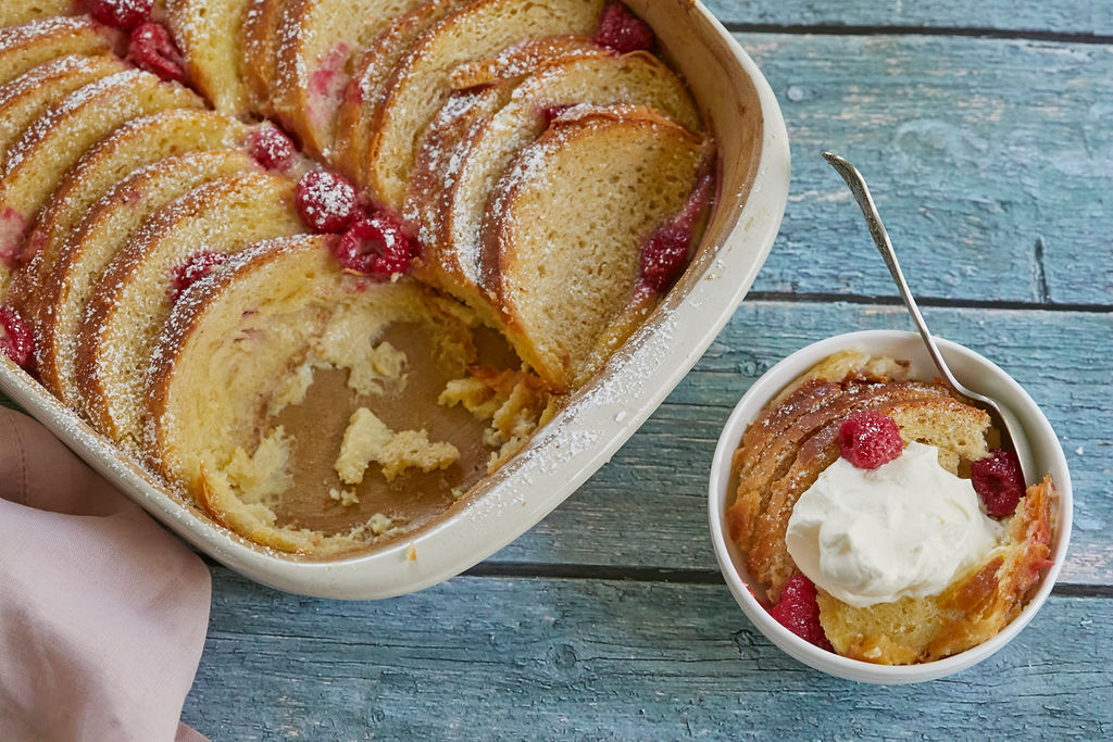 White Chocolate, Whiskey, and Raspberry Bread Pudding recipe serving with whipped cream.