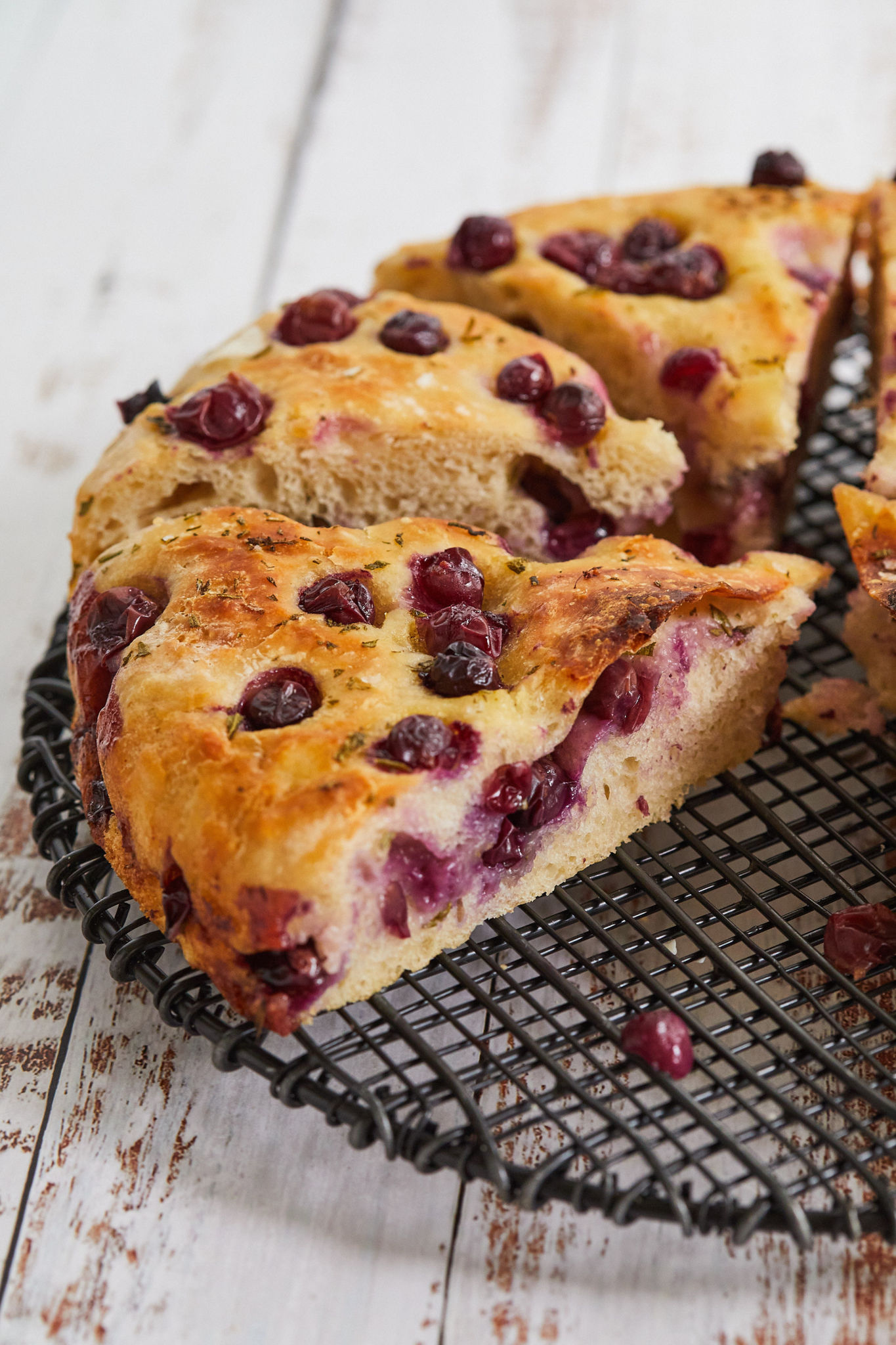 A close of up my grape and rosemary focaccia recipe, showing grapes and interior texture.