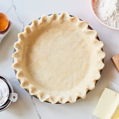 Pie Crust in a fluted pie pan with ingredients around it.