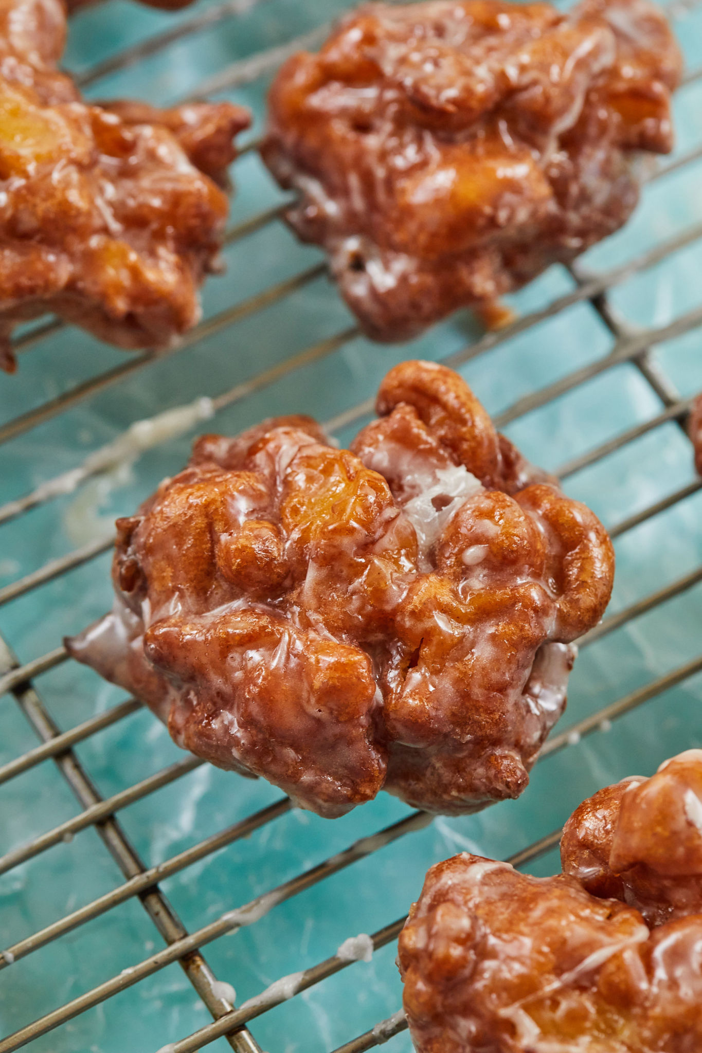 A close up of my apple fritter recipe cooling on a rack.