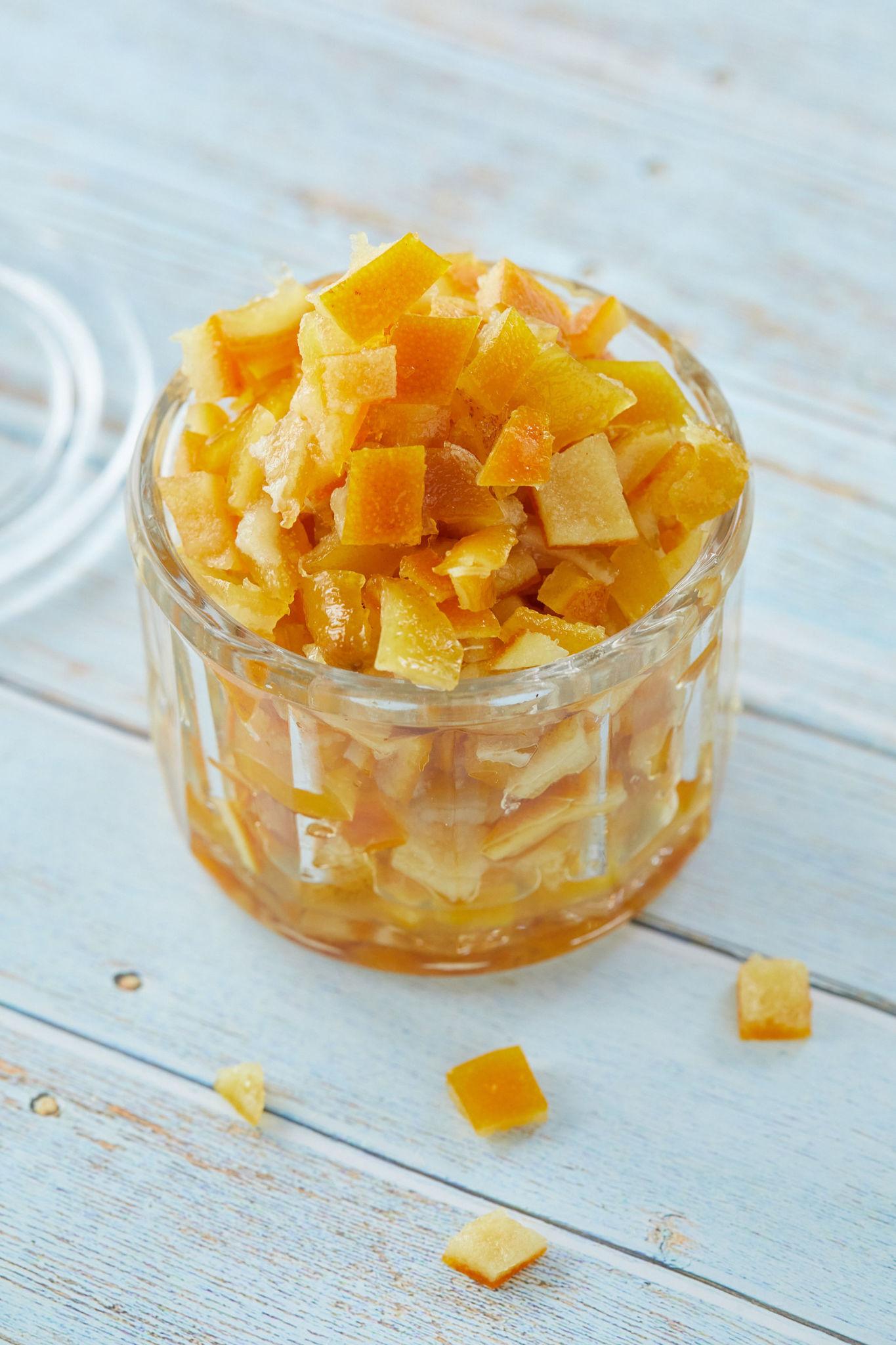 A finished jar of my candied mixed peel recipe on a wood table.