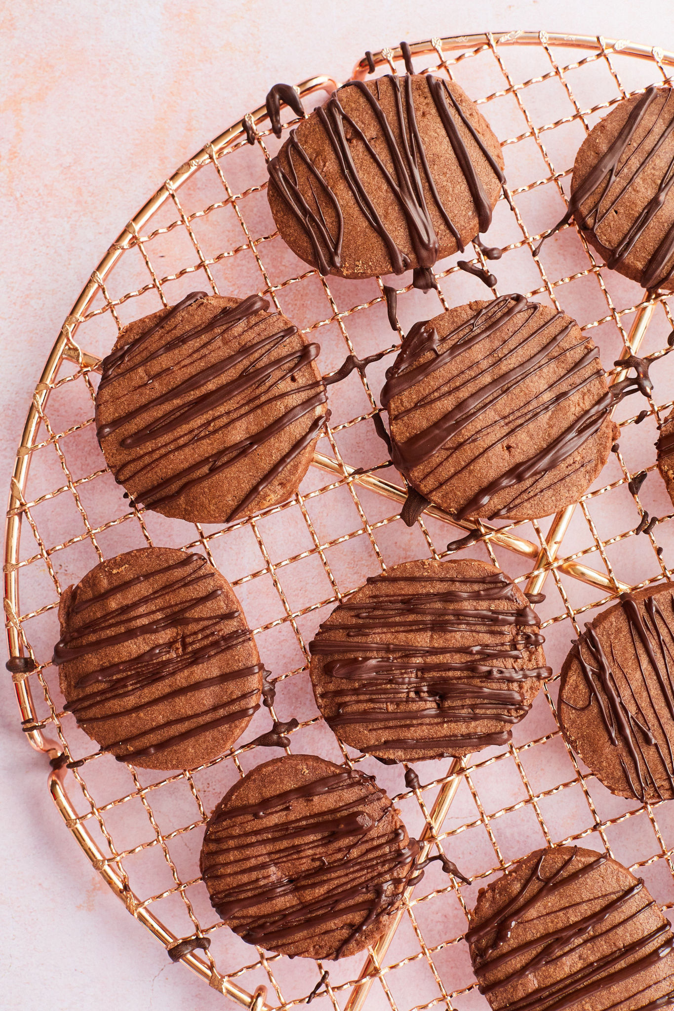 Top-down view of a cooling rack with my chocolate shortbread cookies drizzled in chocolate.