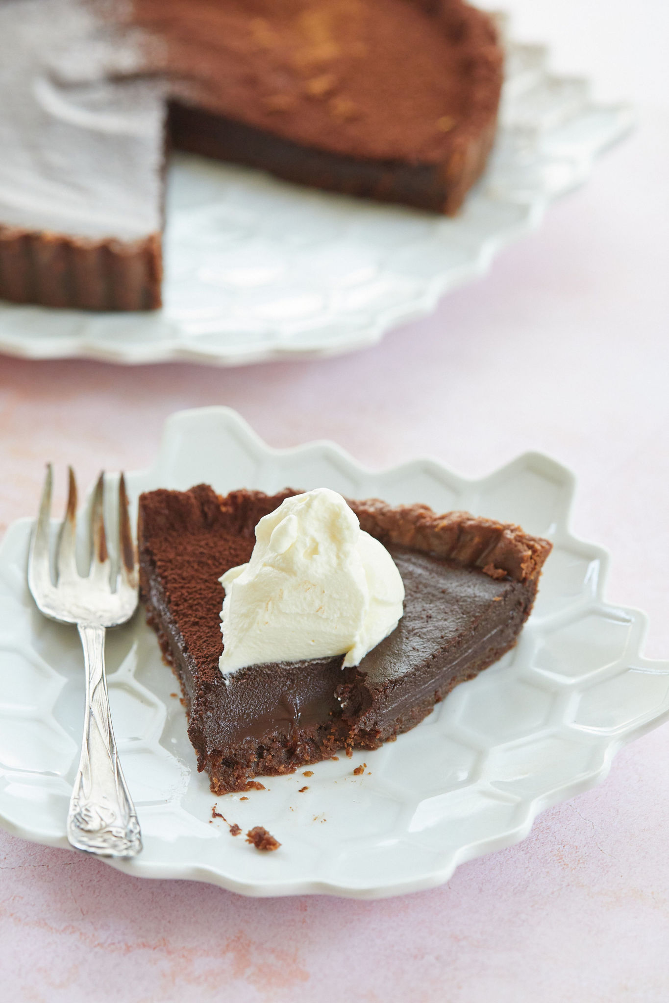 A close of up of the interior of my sinful chocolate tart recipe topped with whipped cream.