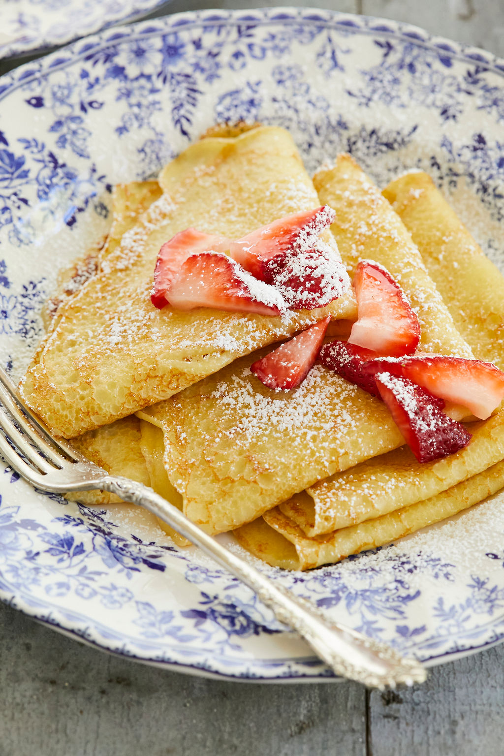 A close-up of my folded crepes to show texture and consistency, topped with powdered sugar and berries.
