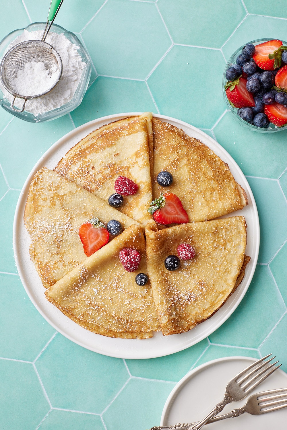 Crepe folded into triangle shapes and served with fresh strawberries and blueberries. 