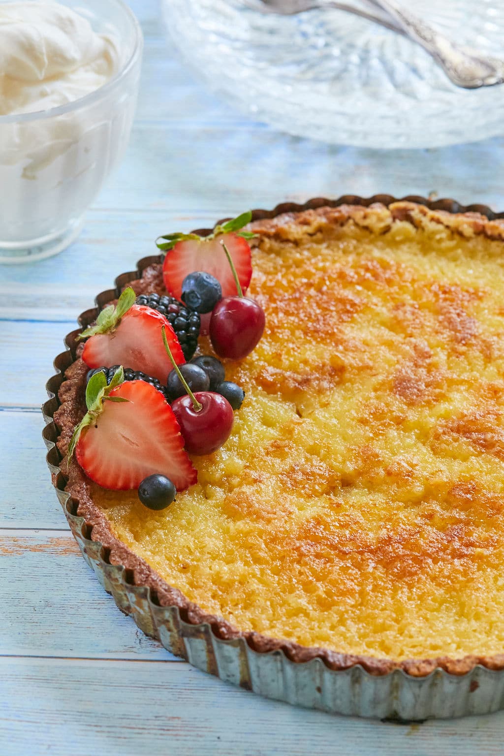 Lemon Tart6 Lemon tart is baked until golden. Topped with fresh strawberries and blueberries, served with softly whipped cream on the side.