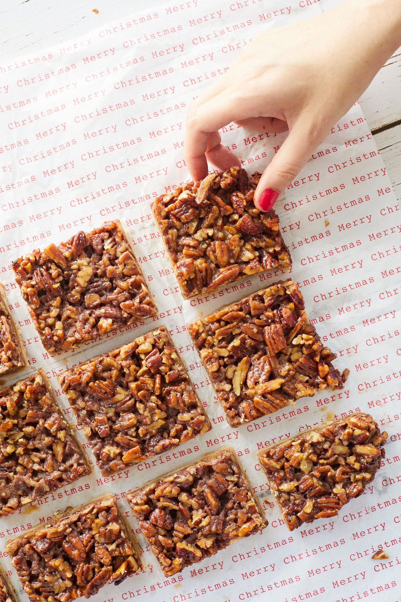 A hand selecting a maple pecan bar from a grid of them.