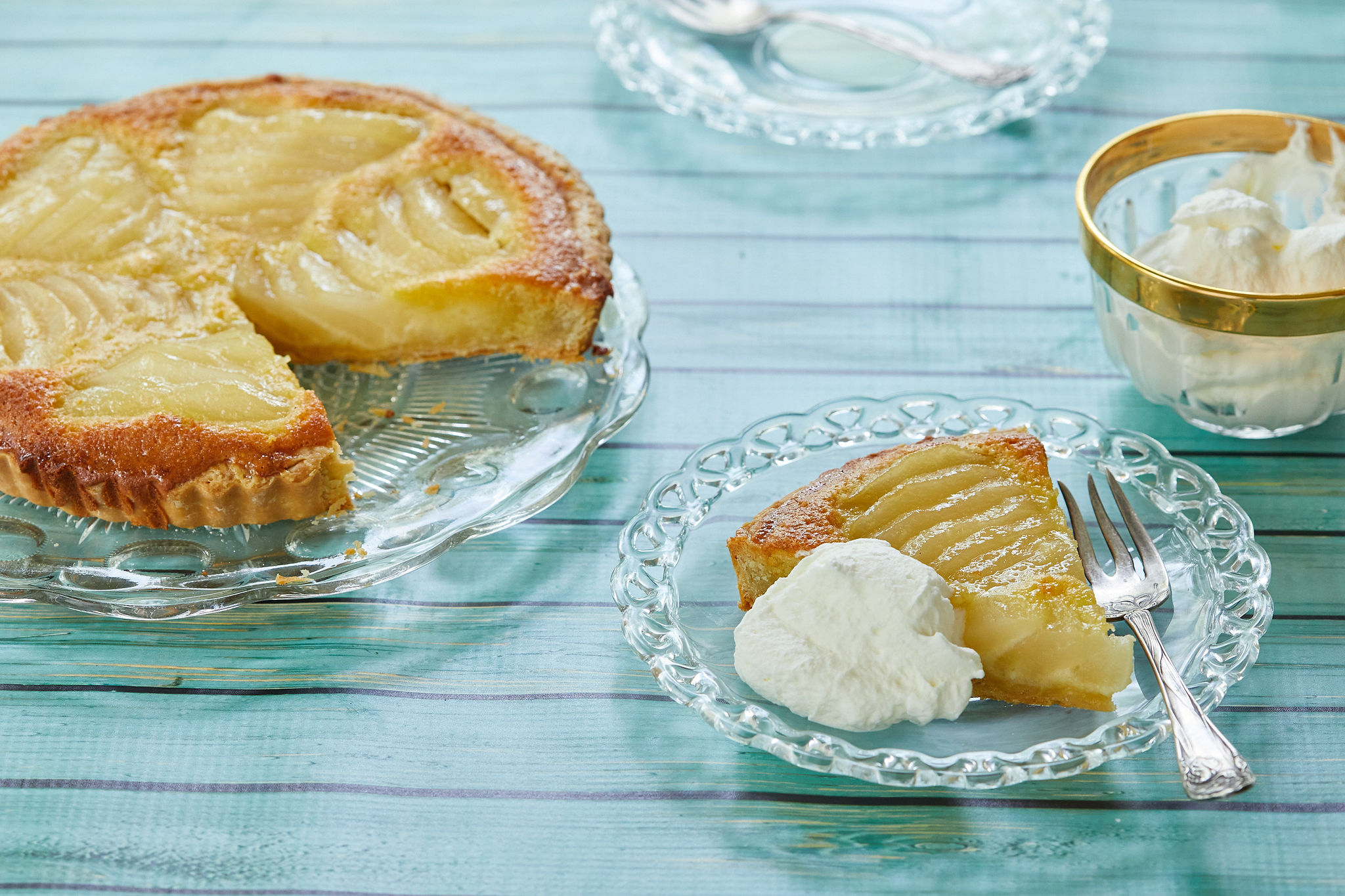 Pear Frangipane Tart, sliced, and served with cream.
