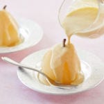 Two poached pears, one with creme anglaise.
