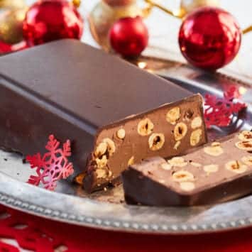 Chocolate & Hazelnut Torrone on a silver platter surrounded by holiday ornaments.