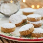 A plate of polvorones covered in powdered sugar.