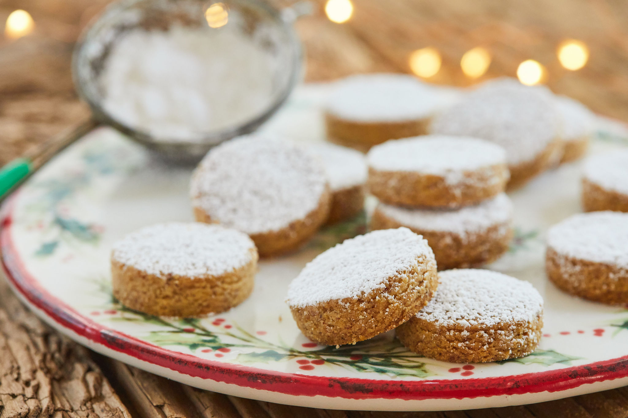 A plate of polvorones covered in powdered sugar.