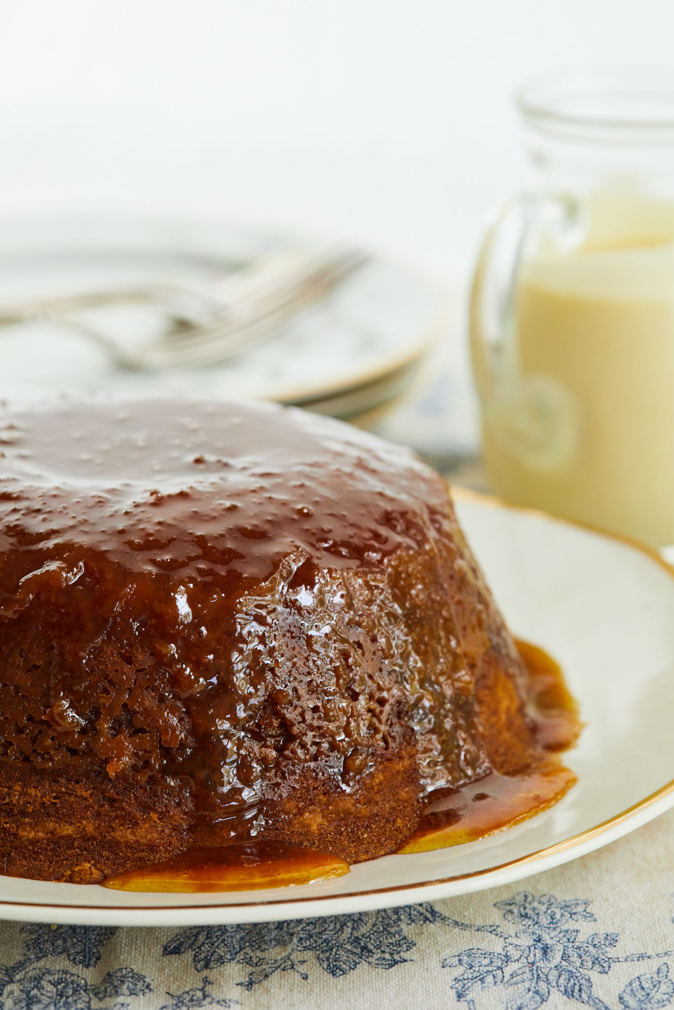 A treacle pudding next to some creme anglaise.