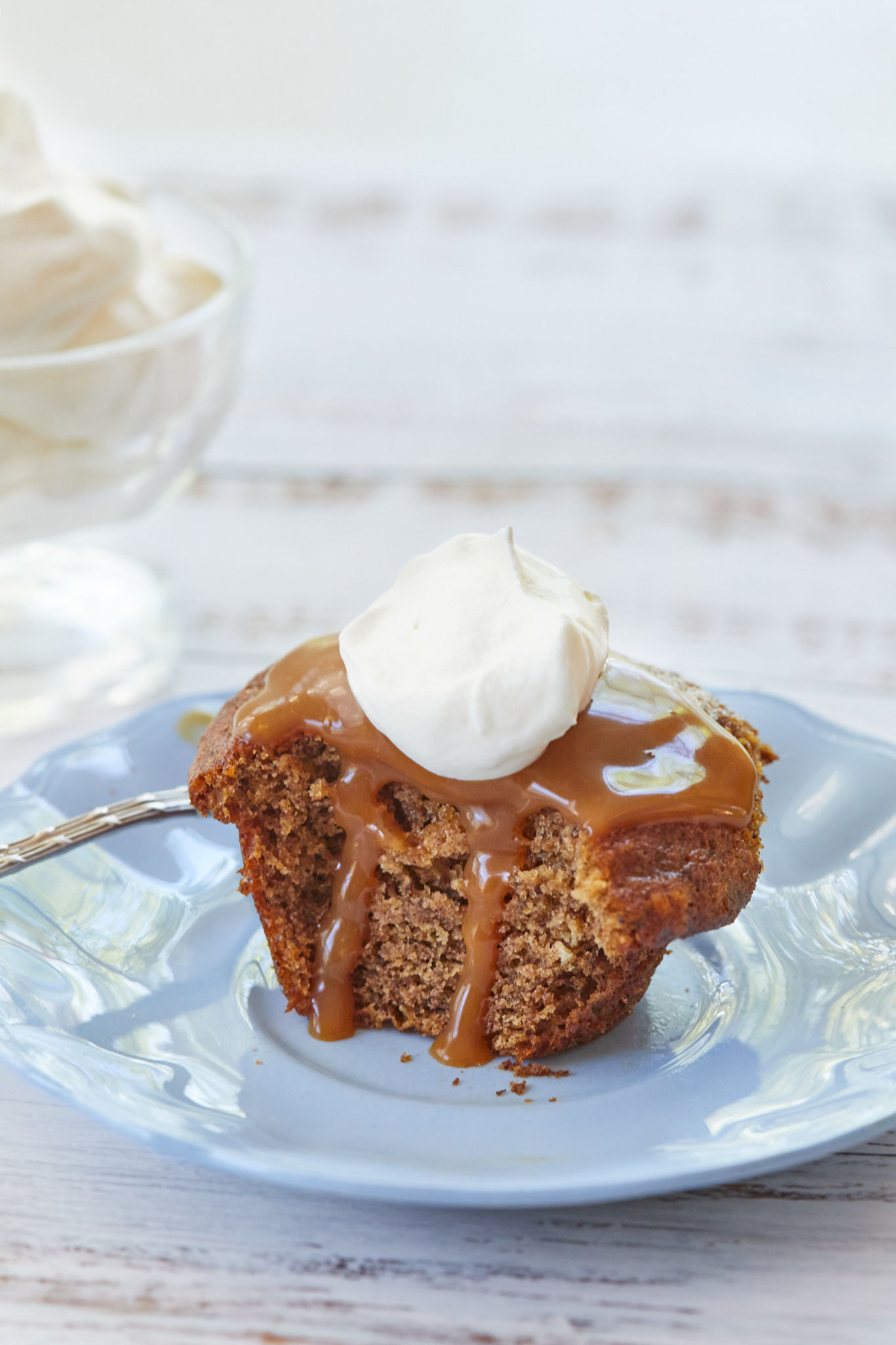 The inside of my English Sticky Toffee Pudding recipe, with salted caramel sauce dripping down the side, and topped with whipped cream.