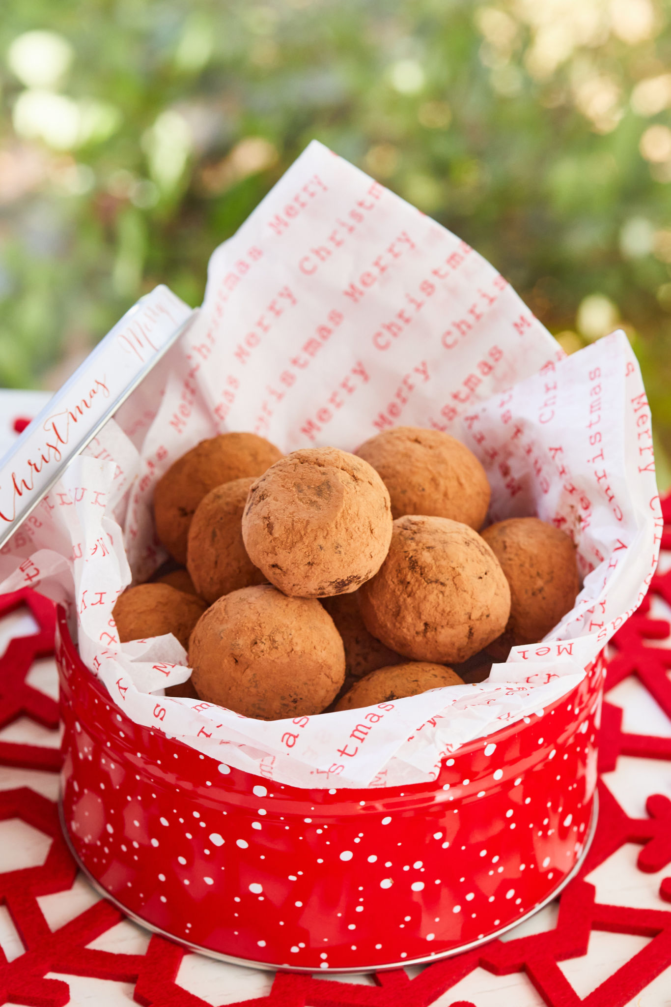 Boozy Holiday Rum Balls in a tin, ready for gifting.
