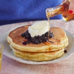 Pouring syrup on my single-serving fluffy pancakes recipe.