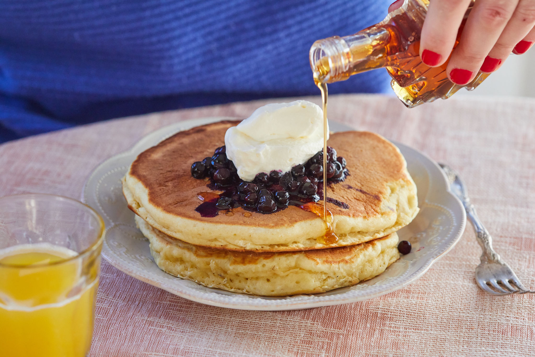 Pouring syrup on my single-serving fluffy pancakes recipe.