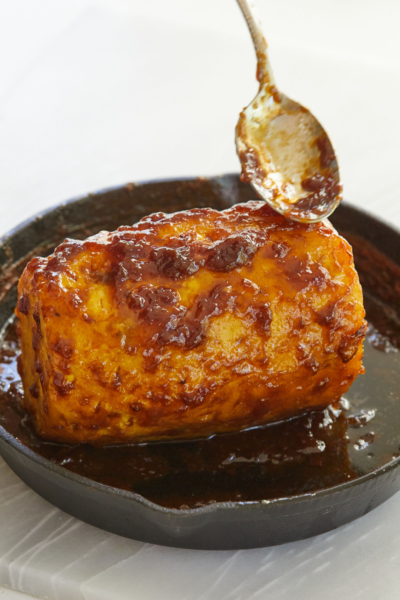 Drizzling butter, rum, and brown sugar on a roasted pineapple