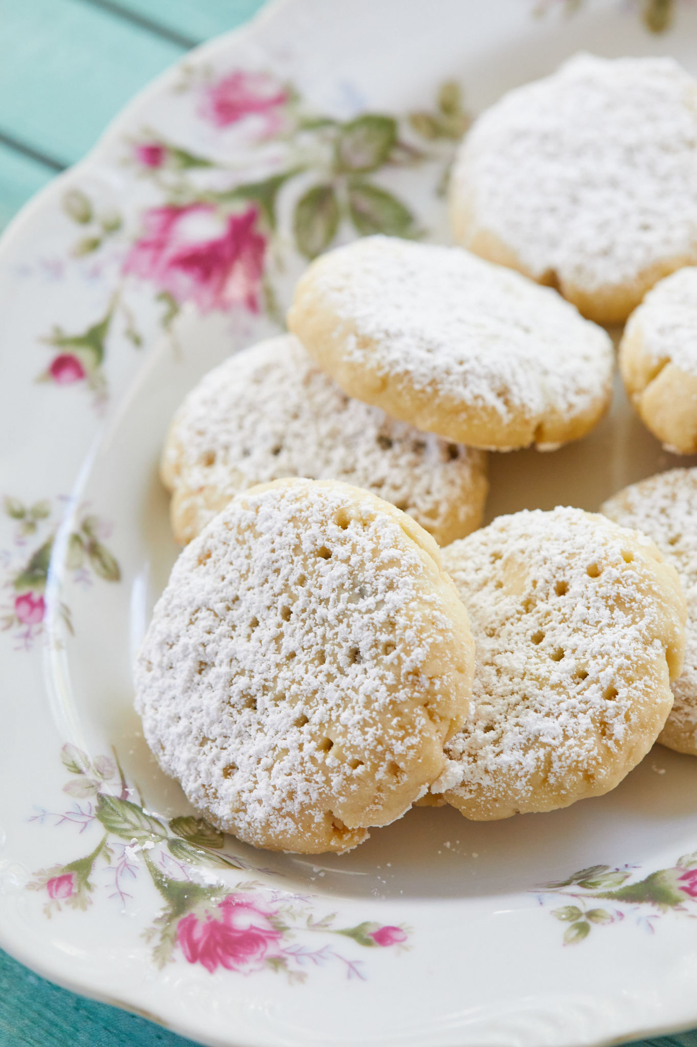 A plate of delicate Maamoul cookies, dusted with powdered sugar.