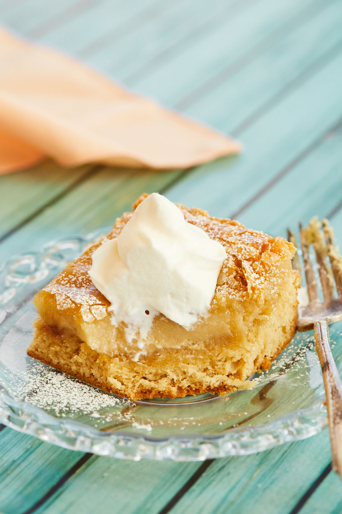 A slice of butter cake, topped with whipped cream.