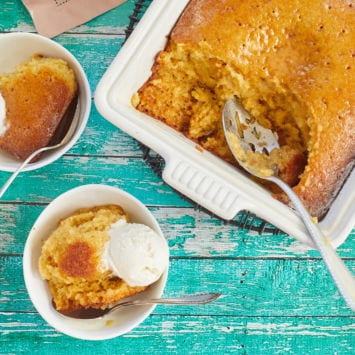 Golden Malva Pudding with soft moist crumb, or cake, portioned out into two bowls.
