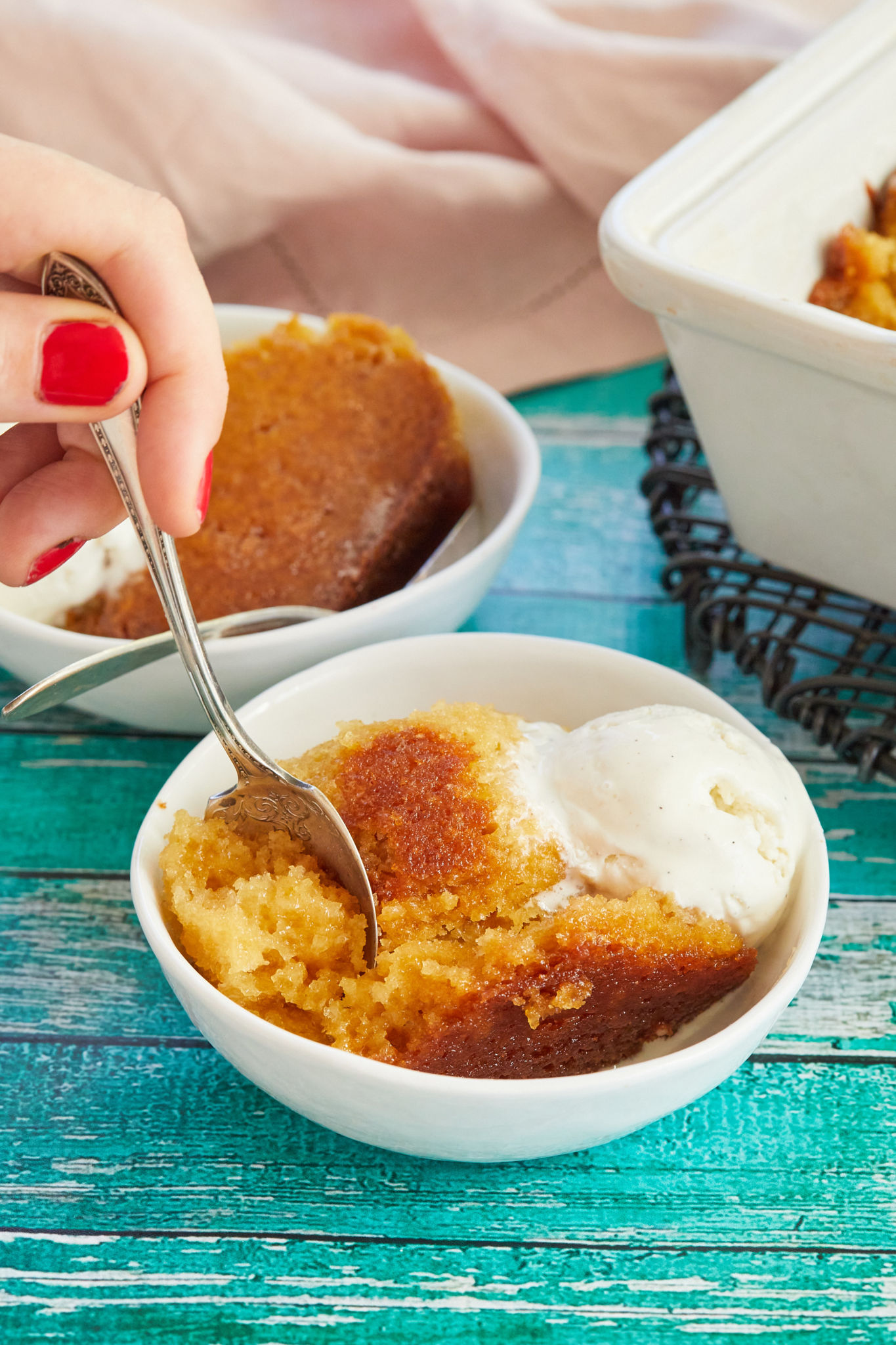 A spoonful of Malva Cake, a pudding recipe from South Africa, topped with vanilla ice cream.