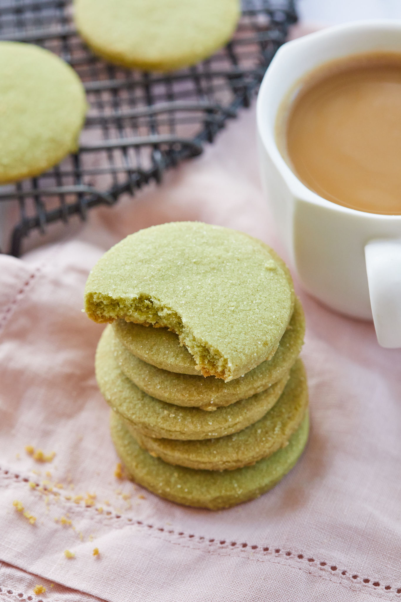 A matcha shortbread cookie with a bite taken out of it