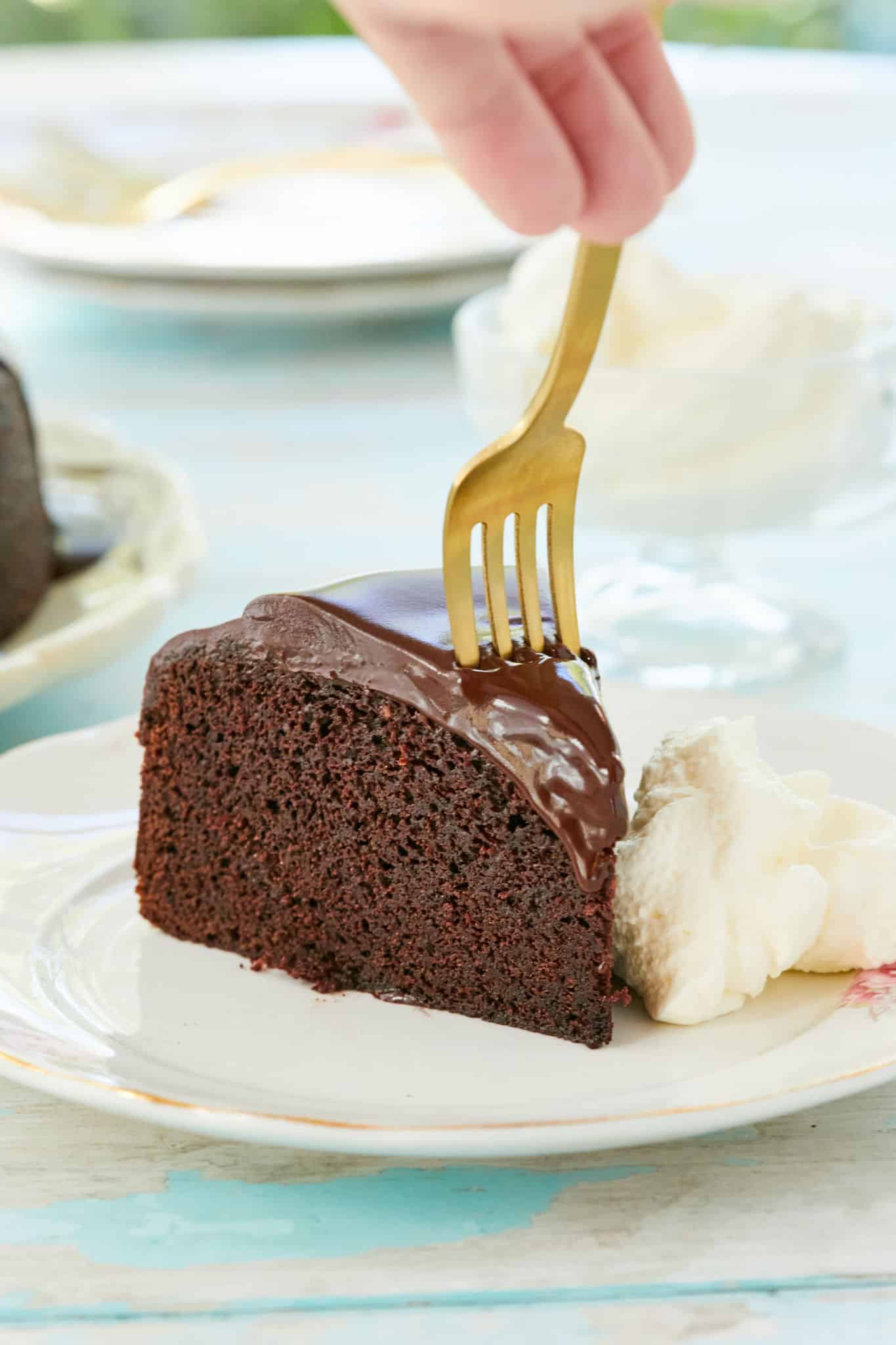 A gold fork going into a slice of chocolate Guinness cake.