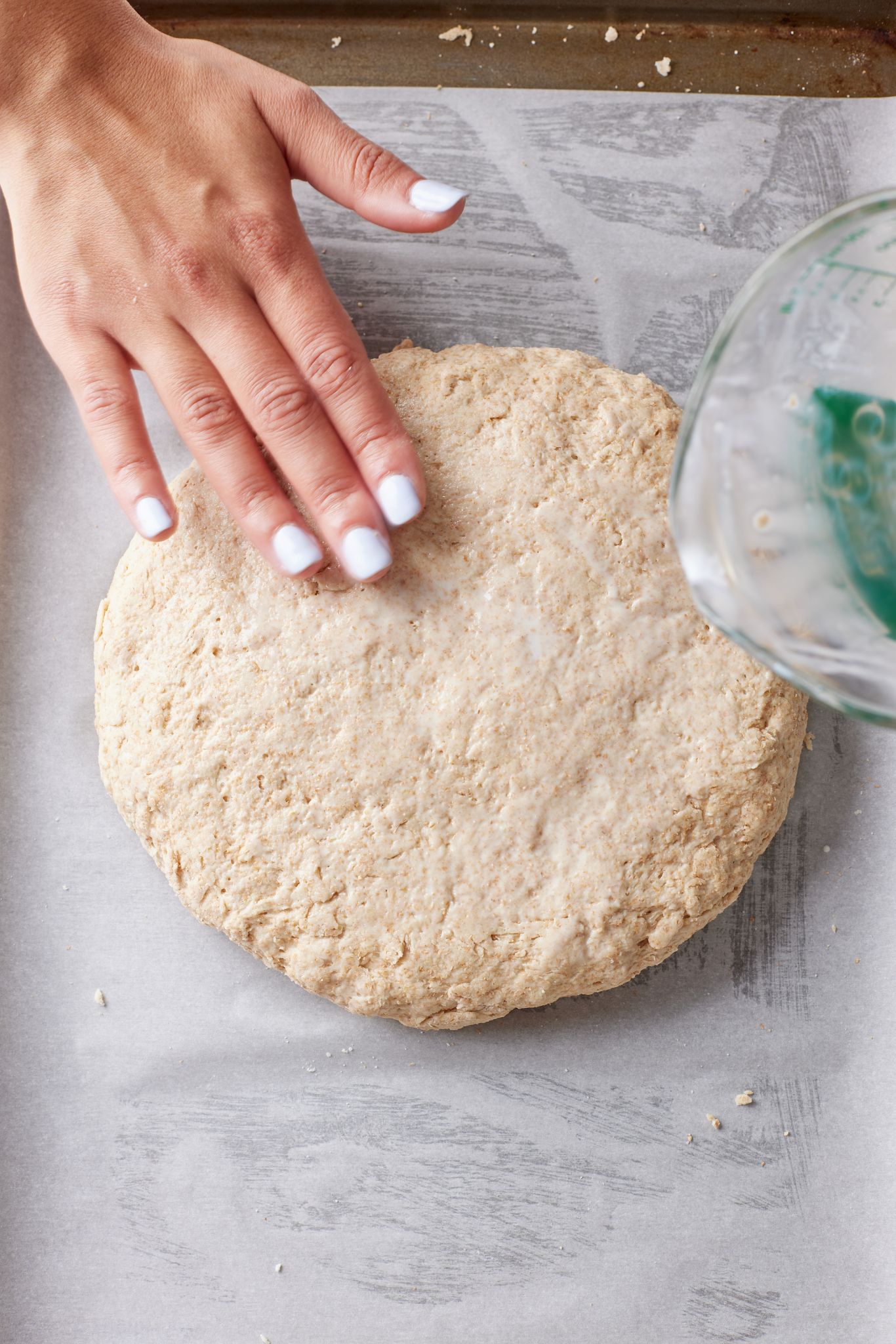 Irish Brown Soda Bread dough was transferred onto a floured surface. Flatten it into an 8-inch round, about 1 ½-inches (4cm) thick.