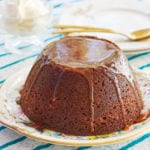 The best Sticky Toffee Pudding recipe served on a plate with a golden spoon.
