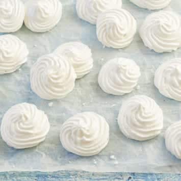 White vegan meringues on parchment.