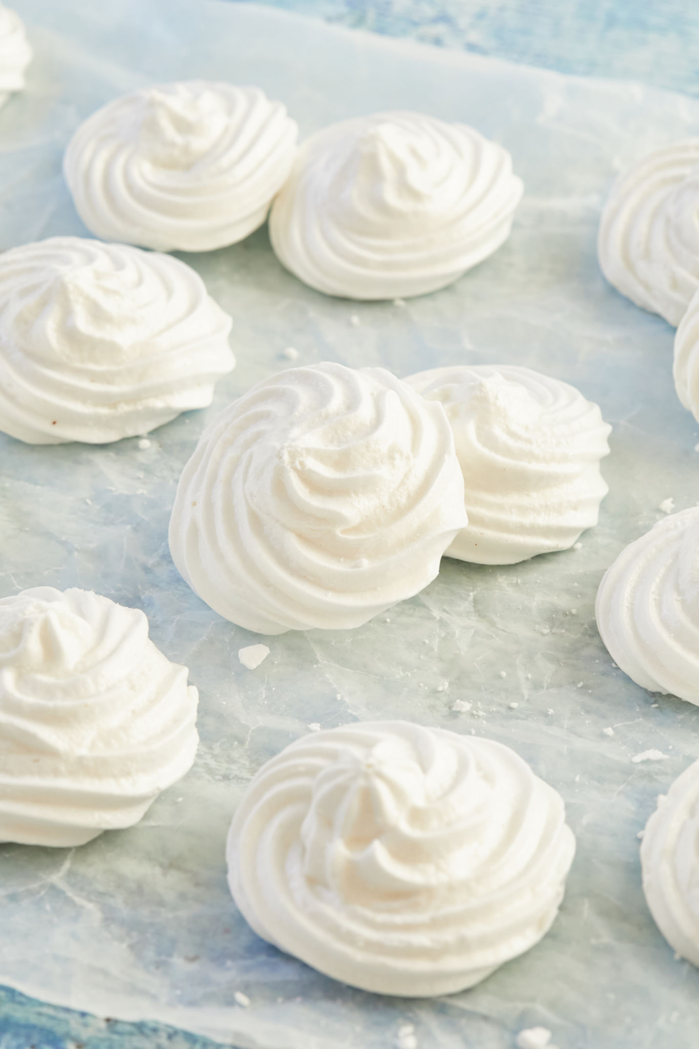 A handful of small vegan meringues placed on parchment.