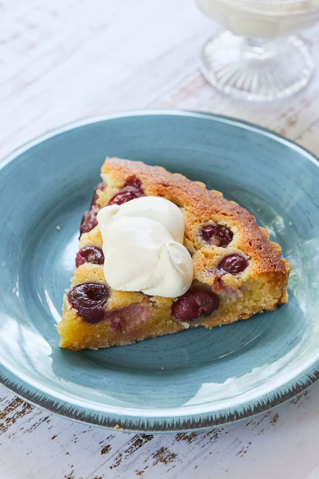 A slice of my cherry almond tart topped with fresh cream.