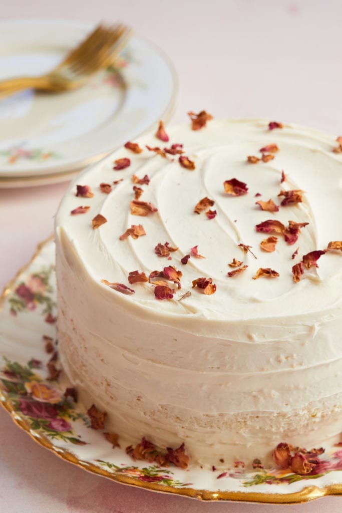 Lemon Cake is frosted with Lemon Buttercream Frosting and topped with dried rose pedals.