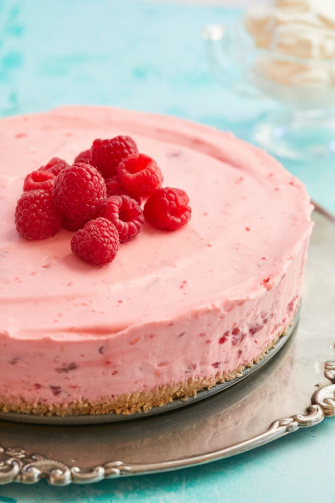 Pink No-Bake Raspberry Cheesecake is in lovely pink color and topped with fresh raspberries.