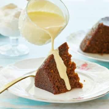 Steamed Carrot Cake Pudding being drizzled with creme anglaise.