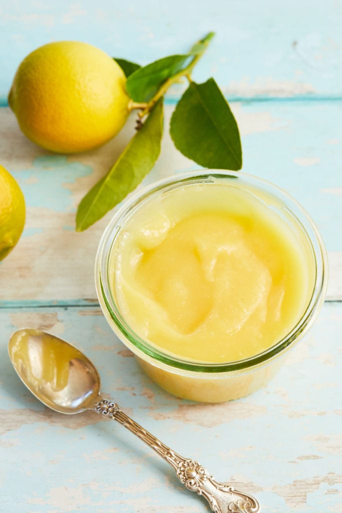 Whole Lemon Curd with a whole and a spoon.