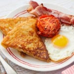 Potato Farls, also known as Potato Cakes, with eggs, bacon, and tomatoes.