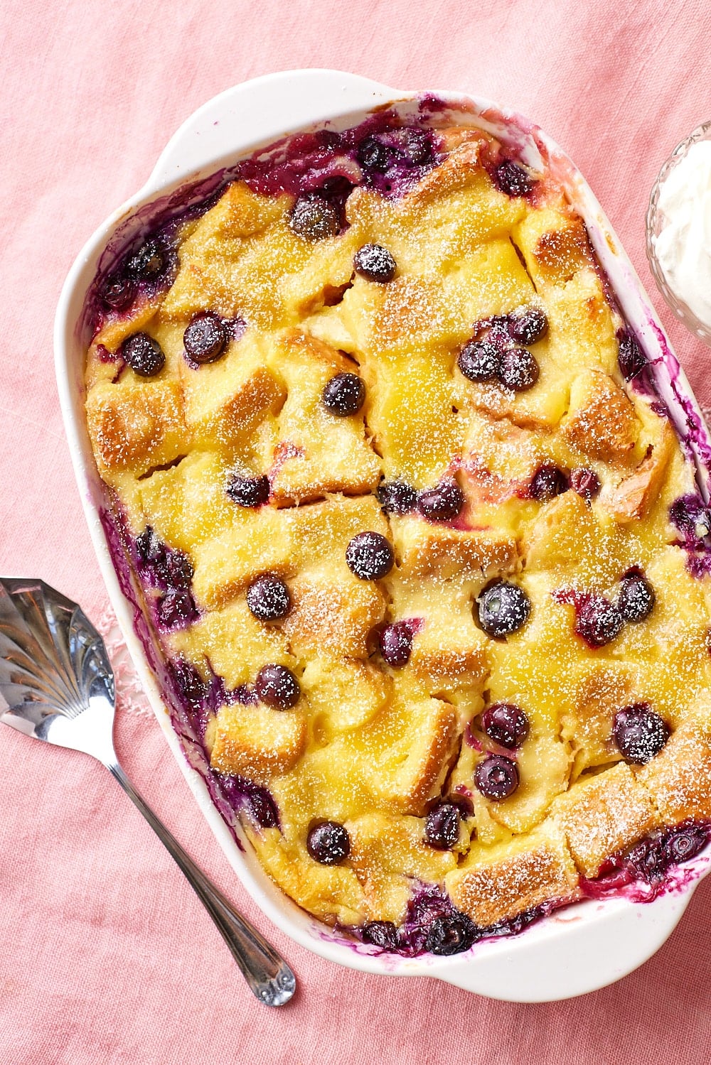 Top down view of a baking dish of golden lemon blueberry bread pudding.