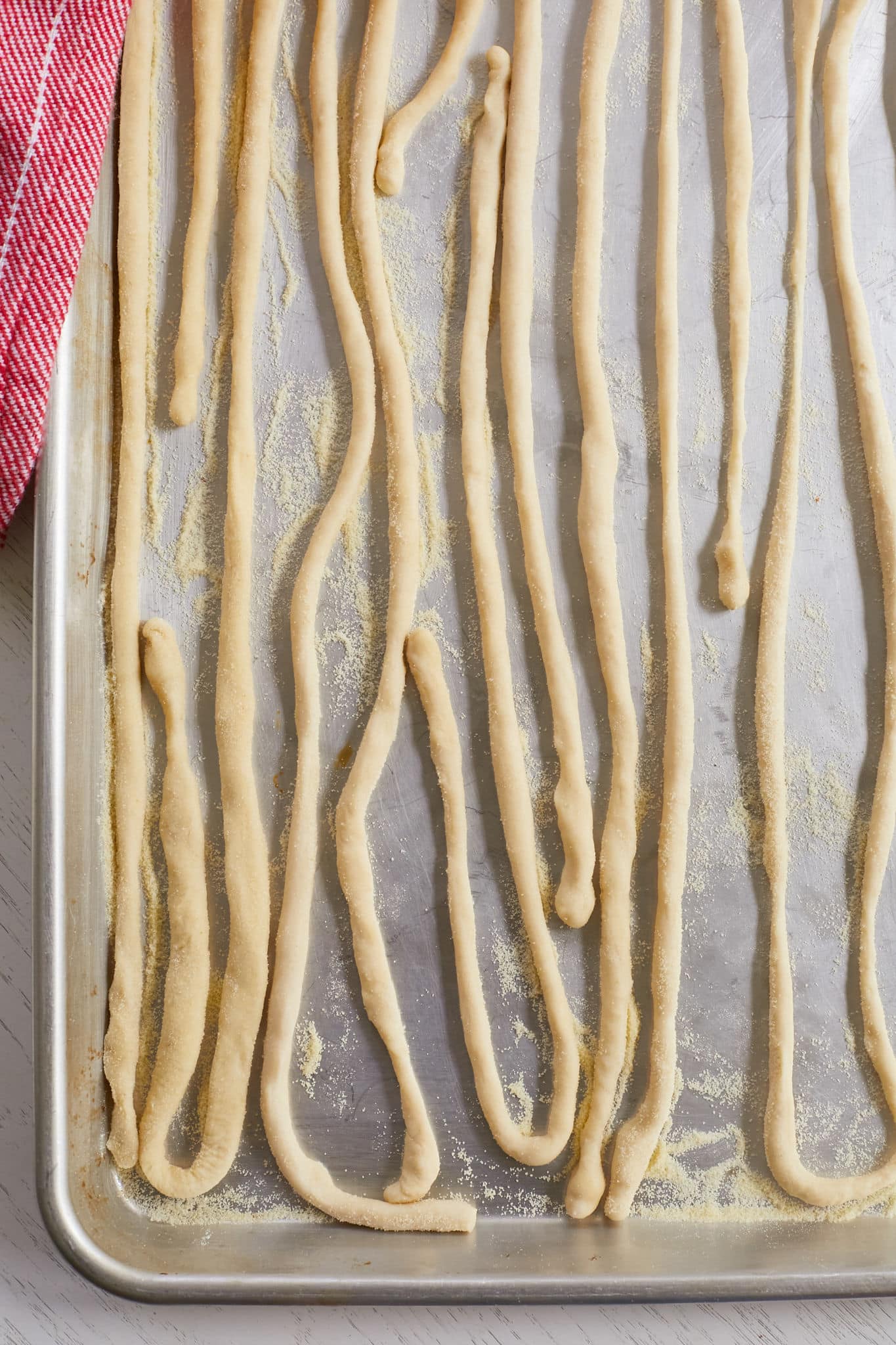 A baking sheet full of pici pasta strands.