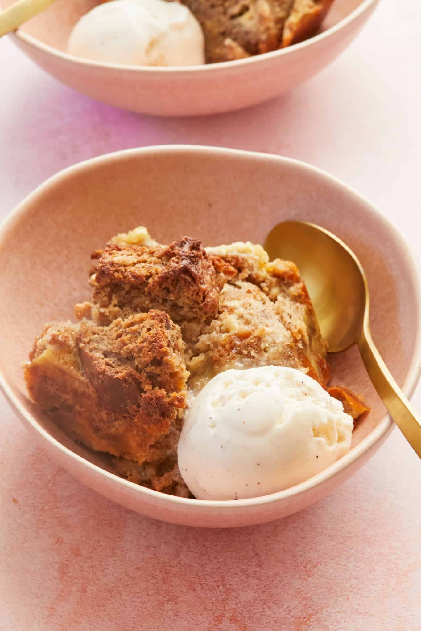 A dish of banana bread pudding with a scoop of vanilla ice cream.