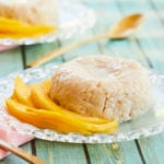 Thai Coconut Sticky Rice, next to some mangoes, on a plate.